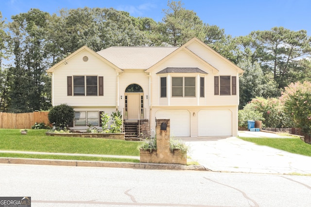 raised ranch featuring a garage and a front lawn