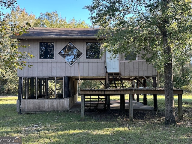 view of front of home with a sunroom, a deck, and a front yard