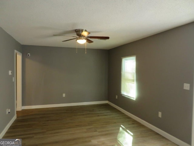unfurnished room featuring baseboards, wood finished floors, a textured ceiling, and ceiling fan