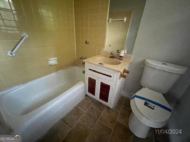 full bathroom with tile patterned floors, vanity, tiled shower / bath combo, and toilet