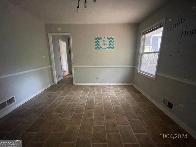 unfurnished dining area featuring dark tile patterned flooring