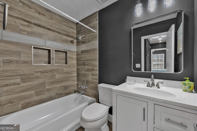 full bathroom featuring vanity, a textured ceiling, toilet, and tiled shower / bath combo