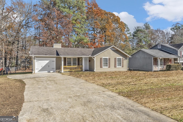 single story home with covered porch, a garage, and a front yard