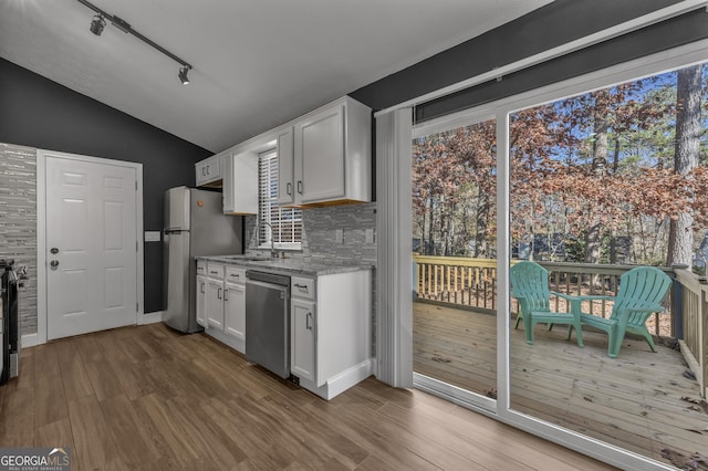 kitchen with hardwood / wood-style floors, stainless steel appliances, white cabinetry, and plenty of natural light