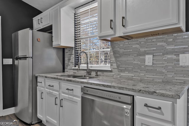 kitchen featuring decorative backsplash, white cabinetry, sink, and appliances with stainless steel finishes