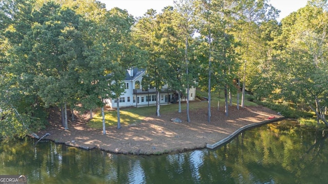 rear view of house featuring a water view and a yard