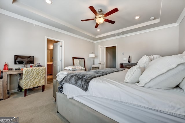 bedroom featuring ensuite bathroom, light colored carpet, ceiling fan, and a raised ceiling