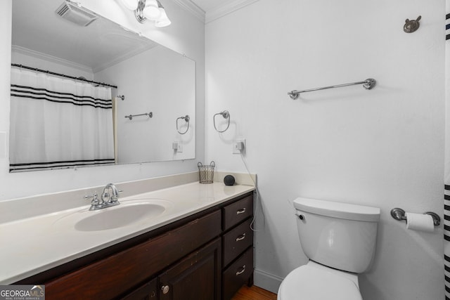 bathroom with ornamental molding, vanity, and toilet