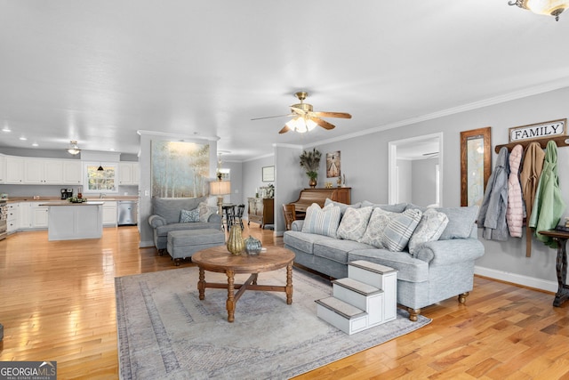 living room featuring crown molding, light hardwood / wood-style flooring, and ceiling fan