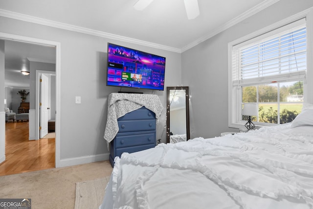 carpeted bedroom featuring crown molding and ceiling fan