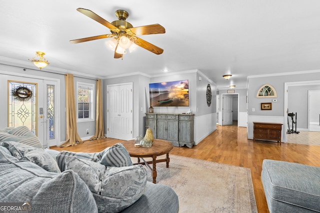 living room featuring light wood-type flooring, crown molding, and ceiling fan