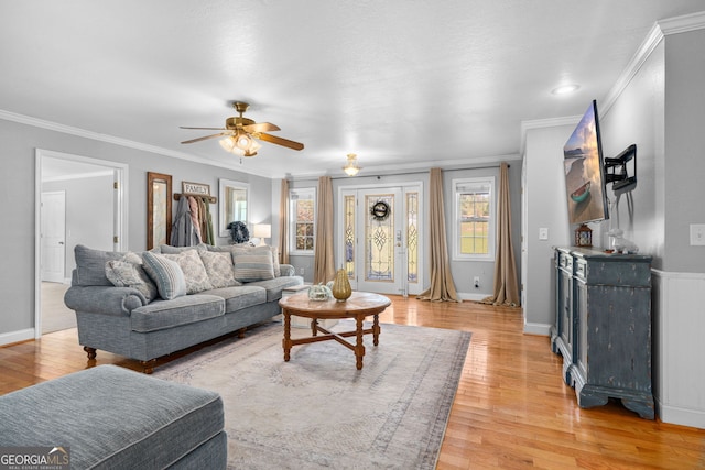 living room featuring crown molding, light hardwood / wood-style flooring, and ceiling fan