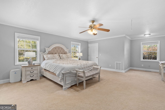 bedroom with multiple windows, ceiling fan, and light colored carpet