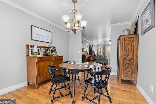 dining room with ceiling fan with notable chandelier, ornamental molding, and light wood-type flooring