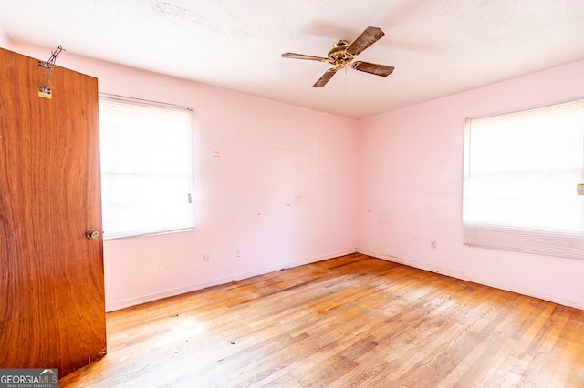 unfurnished room with plenty of natural light, light hardwood / wood-style flooring, and ceiling fan