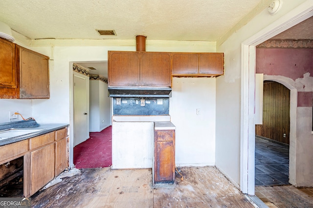 kitchen featuring hardwood / wood-style flooring and a textured ceiling