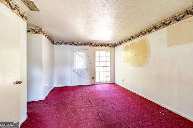 carpeted spare room featuring a textured ceiling