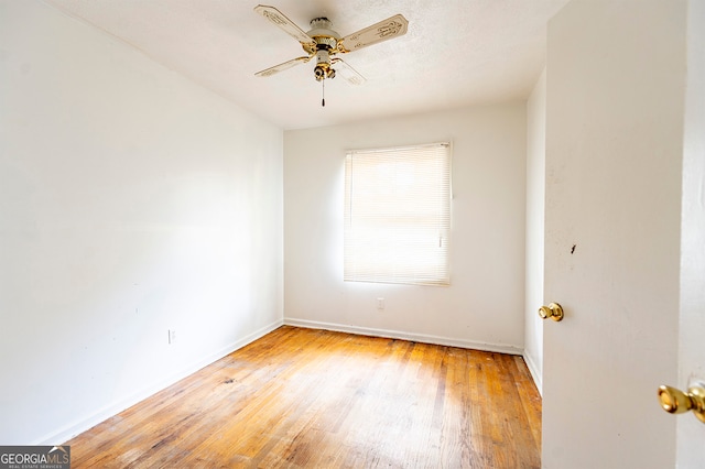 spare room with ceiling fan, wood-type flooring, and a textured ceiling