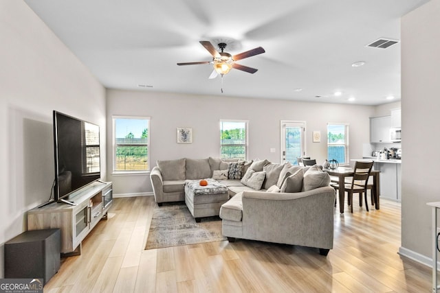 living room with light wood-type flooring and ceiling fan