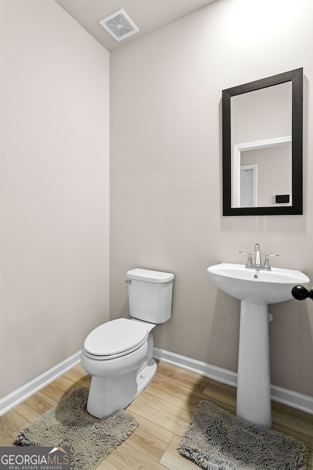 bathroom featuring hardwood / wood-style floors, toilet, and sink