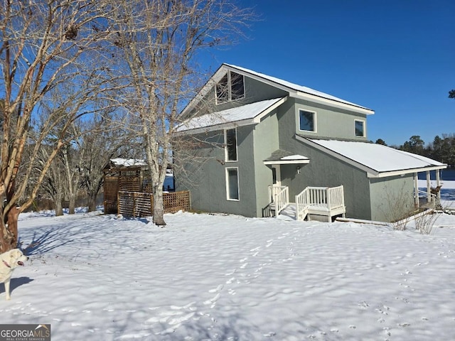 view of snow covered rear of property