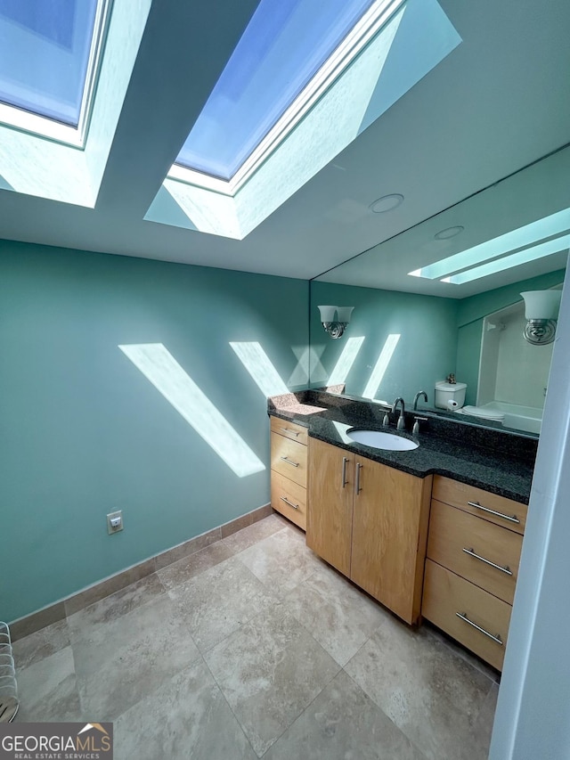 bathroom with toilet, vanity, and lofted ceiling