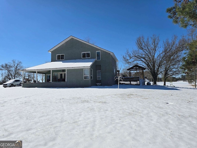 snow covered back of property with a gazebo