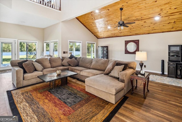 living room featuring a towering ceiling, ceiling fan, hardwood / wood-style floors, and wood ceiling