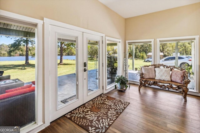 sunroom / solarium featuring a water view, french doors, and a wealth of natural light