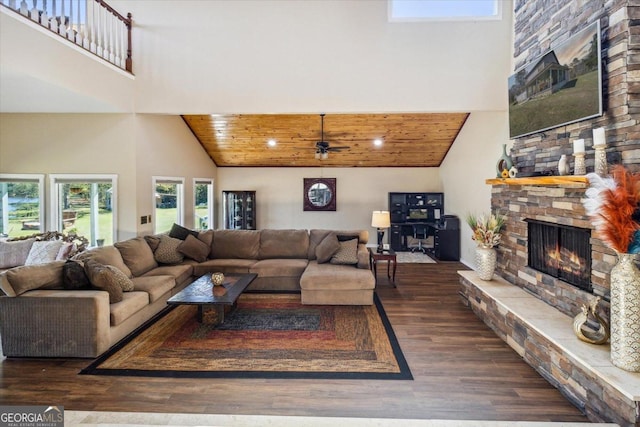 living room with a stone fireplace, wooden ceiling, high vaulted ceiling, and ceiling fan