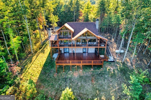 rear view of property with a wooden deck and a yard