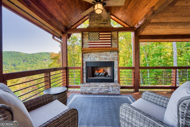 exterior space with an outdoor stone fireplace and ceiling fan