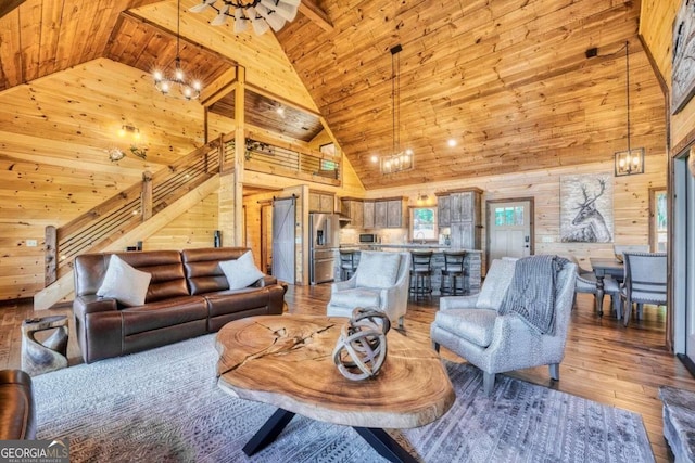 living room with wooden walls, light wood-type flooring, high vaulted ceiling, and wooden ceiling