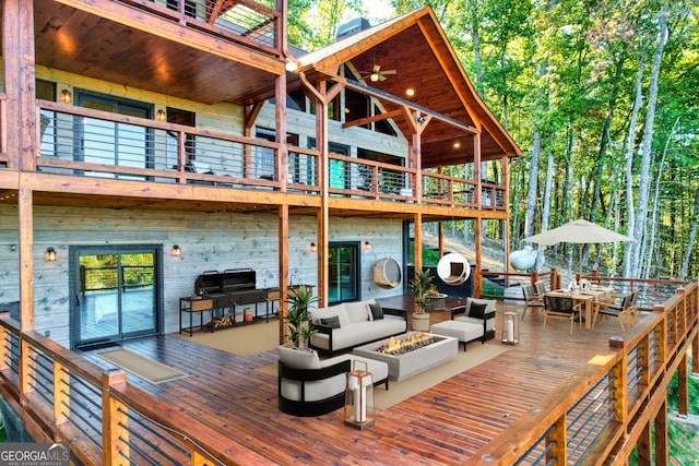 wooden terrace with an outdoor living space with a fire pit