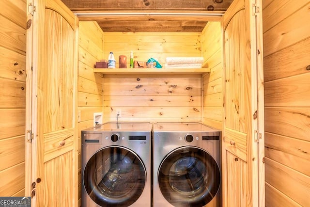 laundry area with washer and dryer and wooden walls