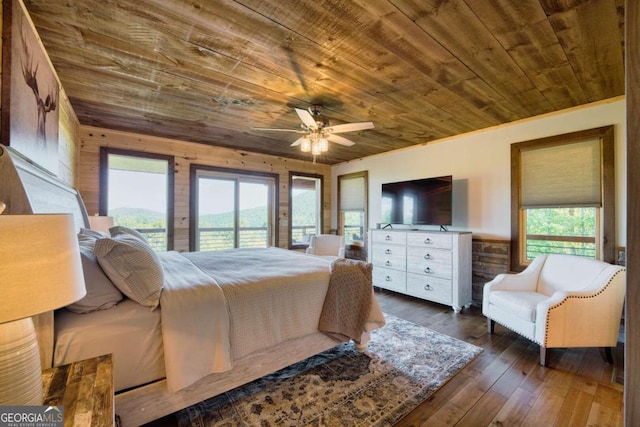 bedroom featuring multiple windows, access to exterior, dark wood-type flooring, and ceiling fan