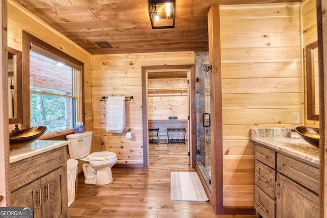 bathroom with wood walls, wood-type flooring, toilet, wooden ceiling, and vanity