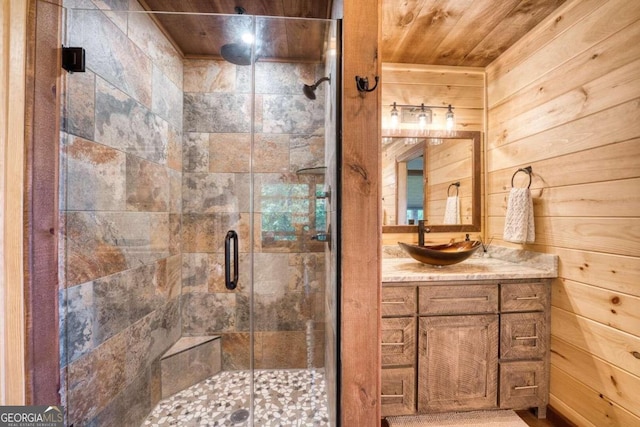 bathroom featuring vanity, wooden walls, a shower with shower door, and wooden ceiling