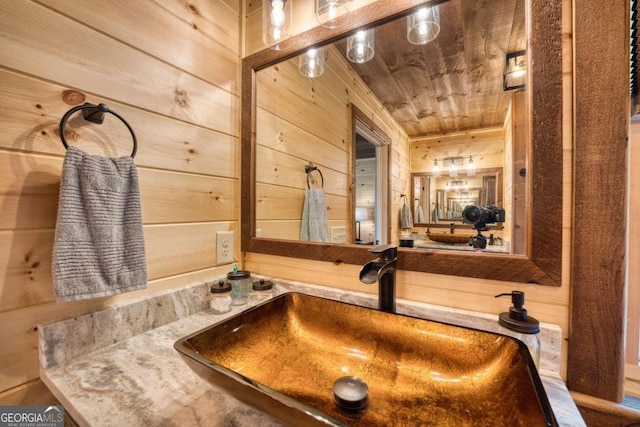 bathroom featuring vanity, wooden walls, and wood ceiling