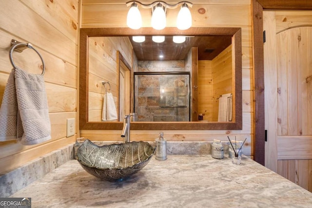 bathroom with walk in shower, sink, and wood walls