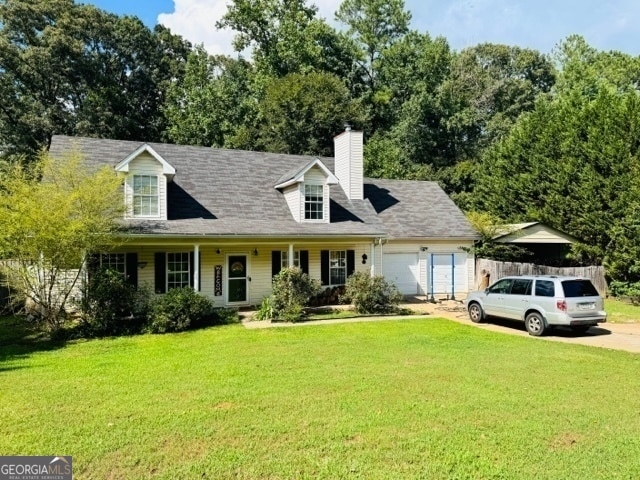 new england style home with a garage and a front lawn