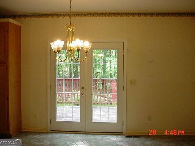 doorway featuring a chandelier, a healthy amount of sunlight, and french doors