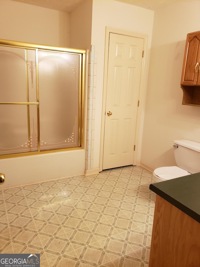 87 Mcmichael Way, Hoschton, GA 30548 - full bath with tile patterned floors, bath / shower combo with glass door, vanity, toilet, and baseboards