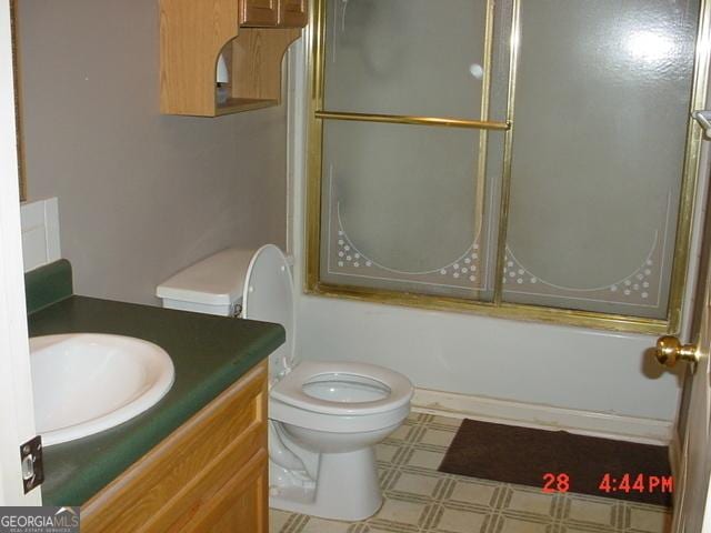 full bathroom with vanity, toilet, and enclosed tub / shower combo