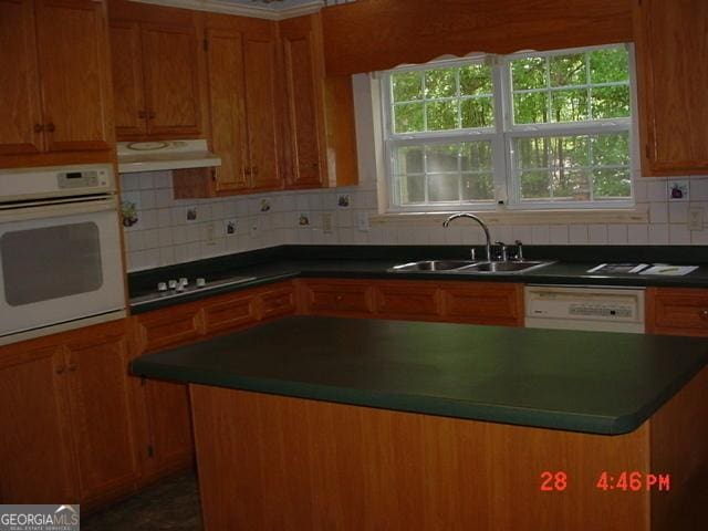 87 Mcmichael Way, Hoschton, GA 30548 - kitchen featuring white appliances, a sink, under cabinet range hood, and dark countertops