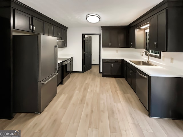 kitchen with stainless steel appliances, light wood-type flooring, and sink