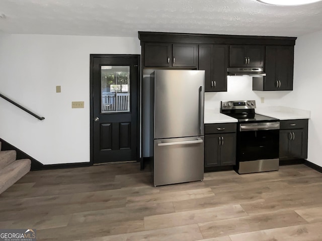 kitchen with stainless steel appliances, light hardwood / wood-style flooring, and a textured ceiling