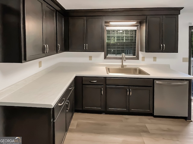 kitchen featuring dishwasher, sink, and light wood-type flooring