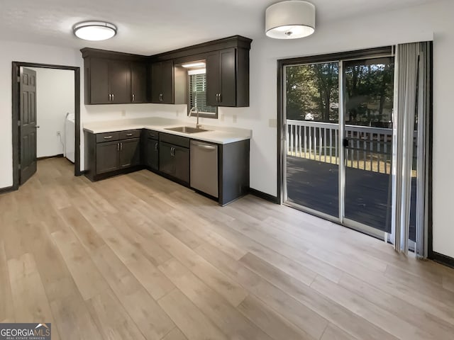 kitchen with light wood-type flooring, dark brown cabinetry, sink, dishwasher, and washer / clothes dryer