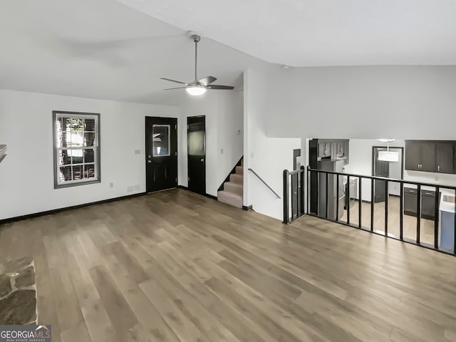 unfurnished living room featuring lofted ceiling, hardwood / wood-style floors, and ceiling fan